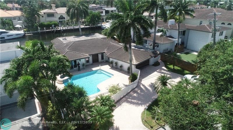 Aerial view of front of the house with circular driveway, gated pool and 2 car garage.