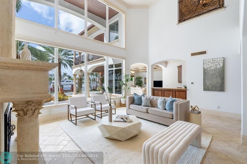 Formal Living Room with gas fireplace, volume ceilings and wet bar perfect for entertaining.