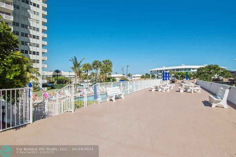 Spacious pool deck for entertaining with a grill, running water and lots of  seating.