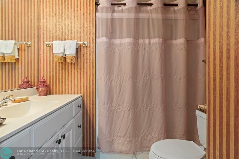 Guest Bathroom and Shower has Glass Shower Doors behind curtain