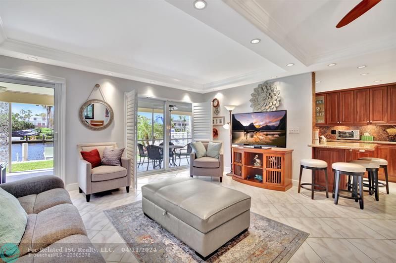 The open living/dining area has an abundance of natural light showcasing the views from the screened in patio off the front.