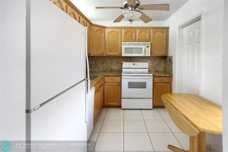 updated kitchen with ceiling fan and service entrance door.