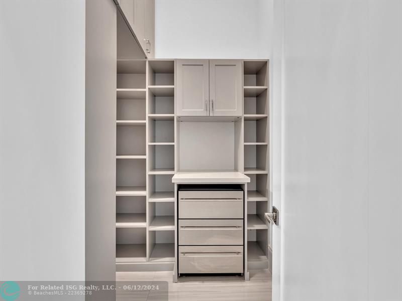 Large walk in pantry with refrigerated drawers and additional shelves on the left