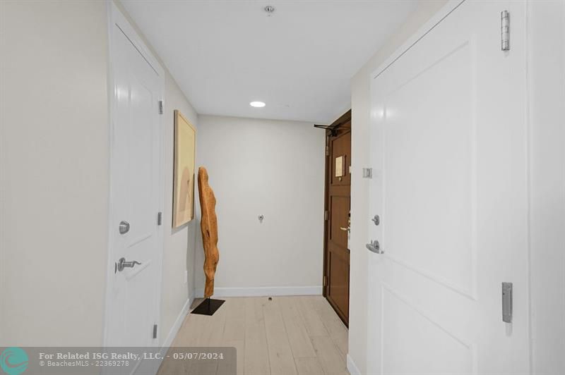 Entrance hall with owner's closet on the left and the door to an adjoining suite on the right.