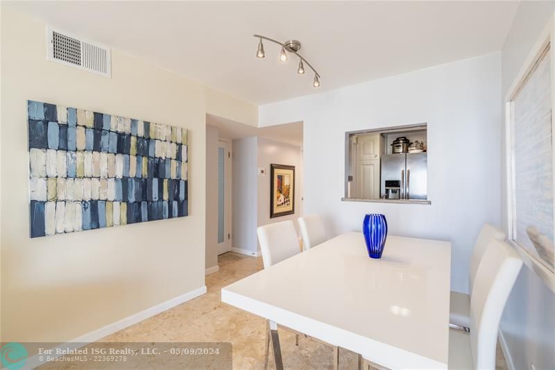 Dining area with a window to kitchen,  The wall can be removed, making the unit more open and seem much larger!