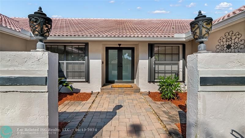 Approach the front door along a charming walkway that guides you through the beautiful landscape scenery. Where lush greenery and carefully placed pavers create an inviting path to your new home.