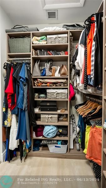 Exceptional custom-fitted walk-in closet showcases built-in shelving, drawers, and hanging rods to accommodate even the most extensive wardrobe and accessories