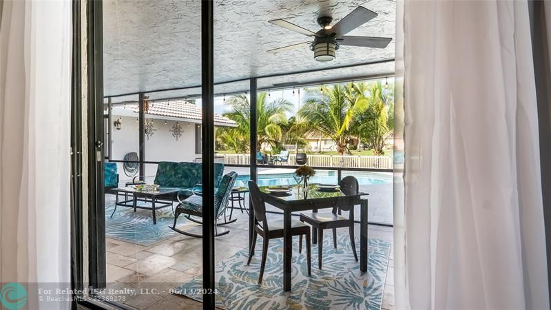 Just beyond the sleek glass doors lies a true outdoor living oasis - the spectacular covered patio space. This exceptional extension of the home seamlessly blends interior comfort with the beauty of Florida's lush natural surroundings.