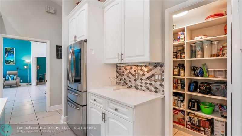 The pantry boasts custom shelving designed to maximize space and accessibility, ensuring all your culinary essentials are within reach.