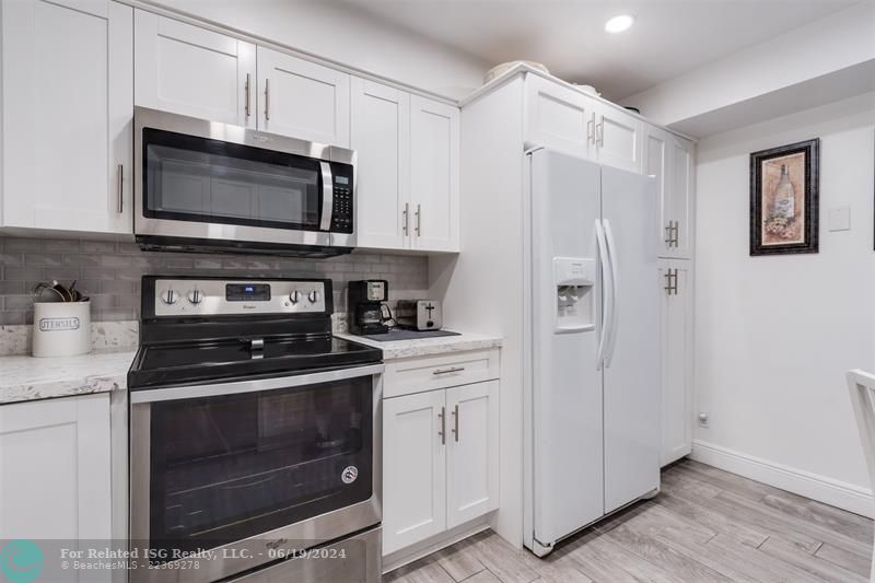 Large capacity Refrigerator next to a large pantry with plenty of storage space.