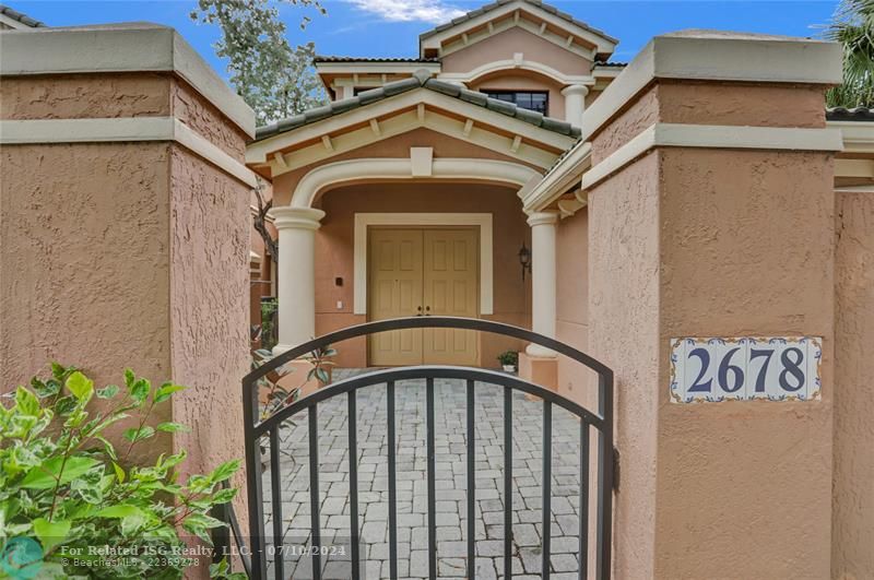 A private gate leads to a charming paver courtyard entry, great spot for plants or your personal touches.