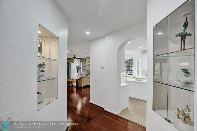 Charming, elegant glass display niches with uplighting, flank the entry way to the living areas.