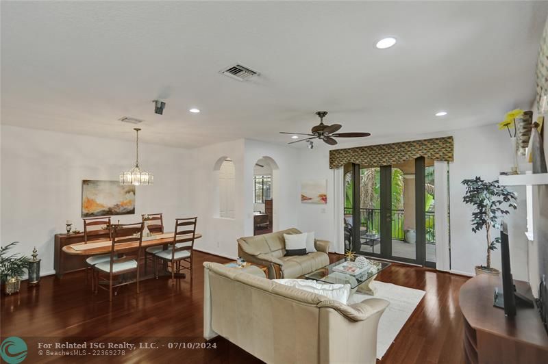 Light, bright, spacious family room with hi-hat lighting, ceiling fan, hardwood flooring.