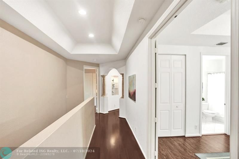 Passageway with hardwood flooring to 2nd guest suite with double door entry, large walk-in closet and bathroom ensuite.