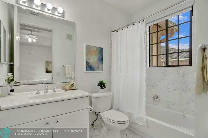 White on white ensuite full bathroom with tub/shower.