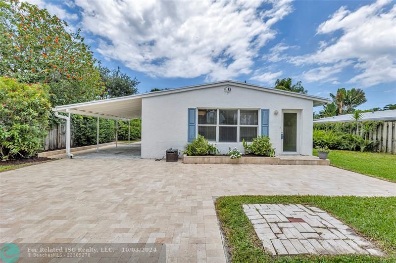 Front entrance with large patio, driveway, carport