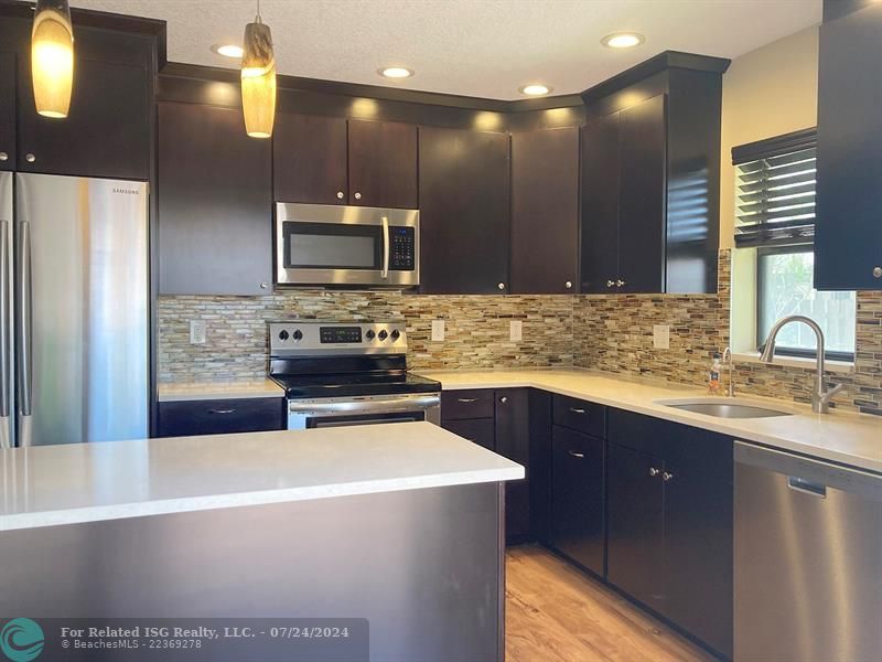 Beautiful working kitchen with creamy quartz counters, center island