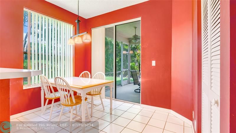 Full eat in kitchen or dining area with pantry, sliding glass doors leading out to screen roofed patio