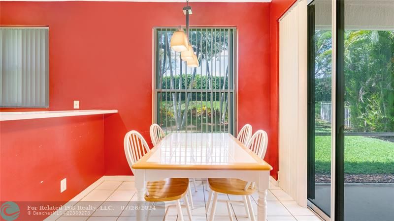 Full eat in kitchen or dining area with pantry, sliding glass doors leading out to screen roofed patio