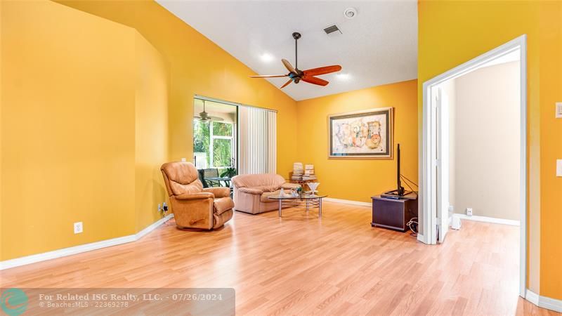 Family room with sliding glass doors leading out to roofed screened patio