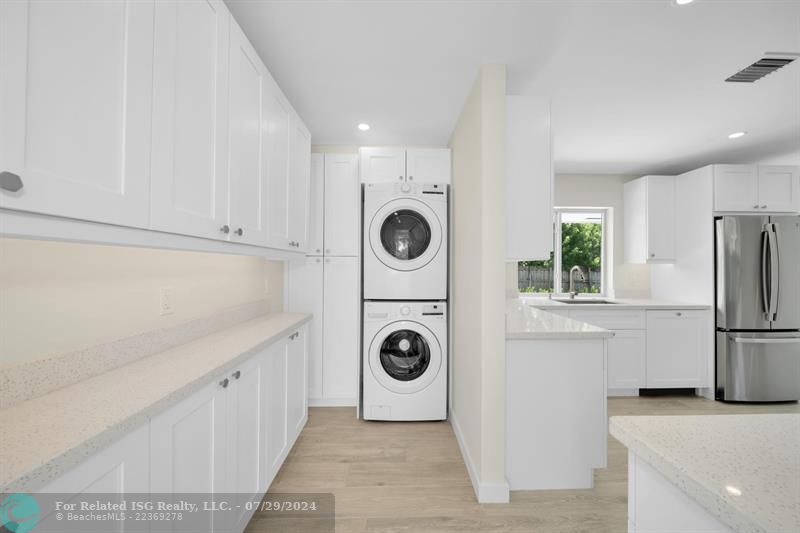 Laundry with plenty of storage and efficient tankless water heater.