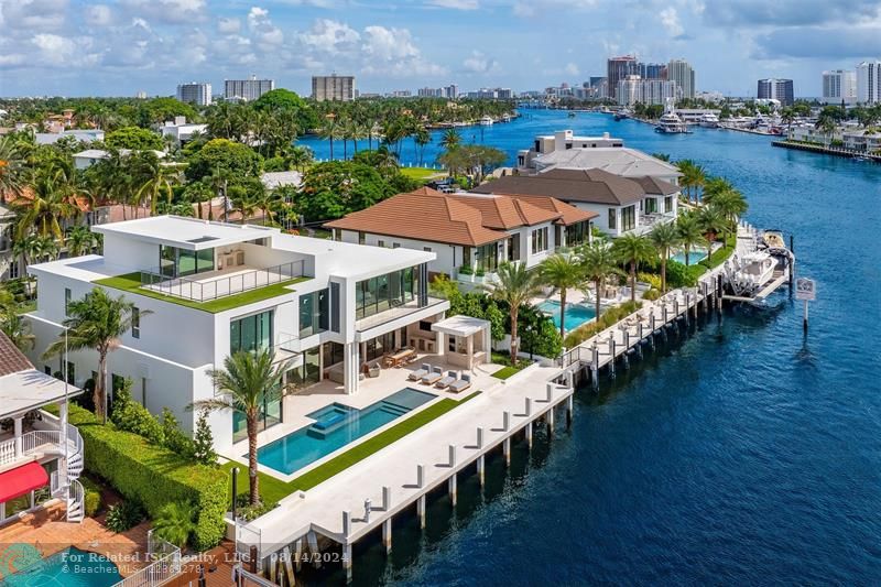 White home centered with backyard facing water. Views of Downtown Fort Lauderdale