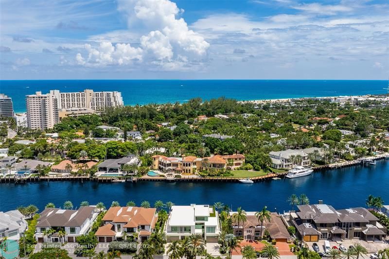 White home centered with backyard facing water. Views of Downtown Fort Lauderdale