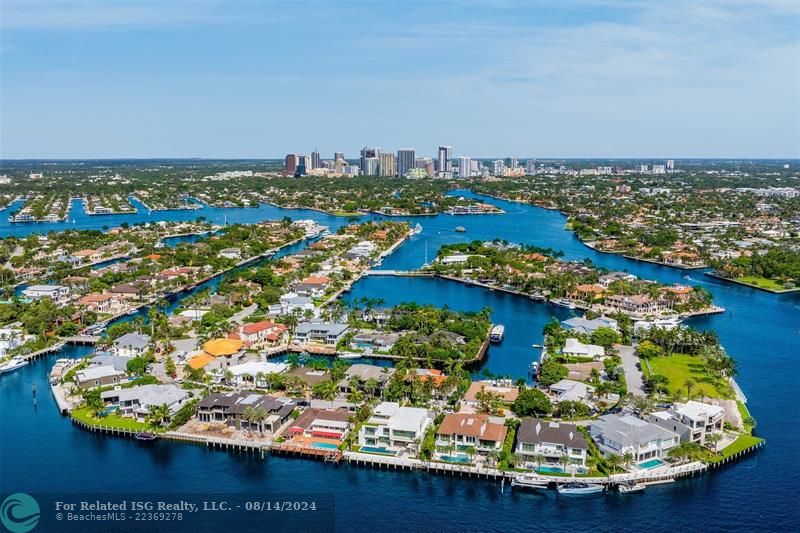 White home centered with backyard facing water. Views of Downtown Fort Lauderdale