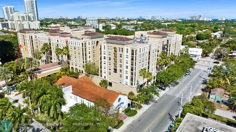 Small Dinner Theater, with red roof, near Condo.  See Yellow and Red arrows on left side of picture. Two balconies in unit 2404. Yellow arrow , this side of unit faces West. Red arrow, this side of building West and other side of unit faces north.