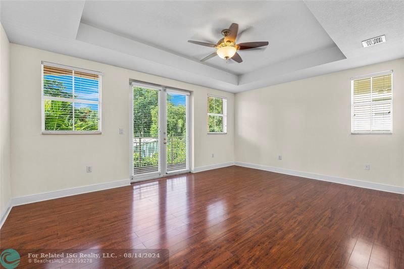 Primary suite w/balcony and pool view.