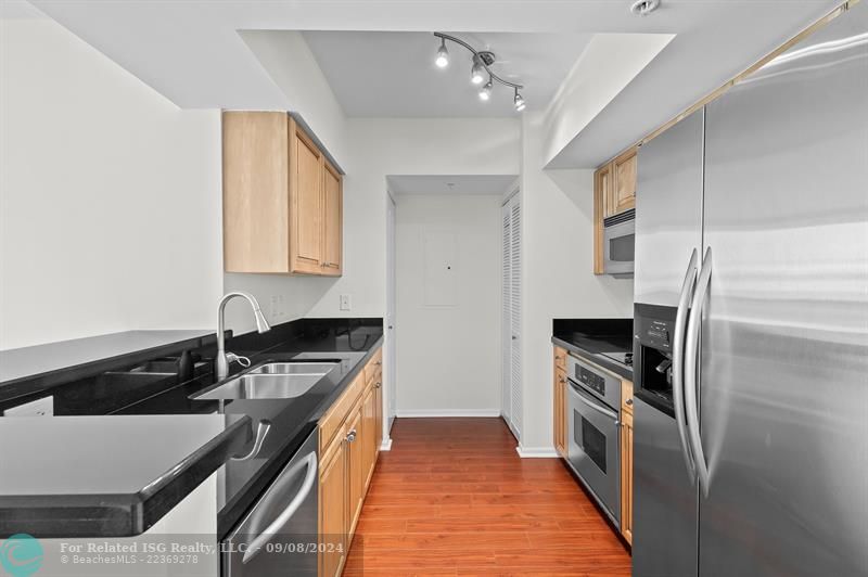 Laminate wood floors throughout  the residence, large pantry closet on left at end & laundry on right in closet.  Counter seating on left.