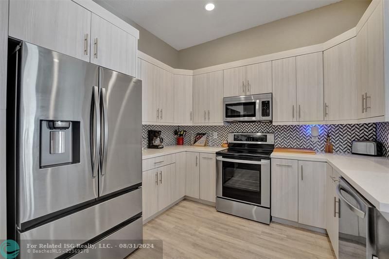 Entry with the garage access on the left and half bath on the right leading to the kitchen and living room.