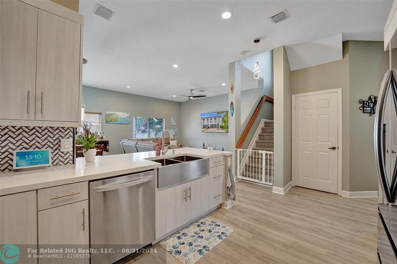 Entry with the garage access on the left and half bath on the right leading to the kitchen and living room.