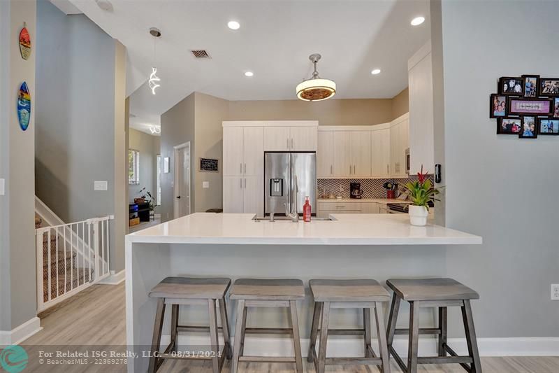 Entry with the garage access on the left and half bath on the right leading to the kitchen and living room.