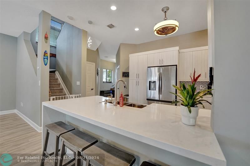 Entry with the garage access on the left and half bath on the right leading to the kitchen and living room.