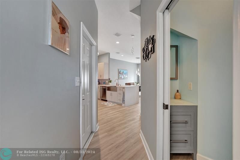 Entry with the garage access on the left and half bath on the right leading to the kitchen and living room.