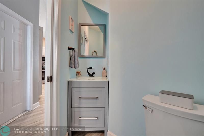 Entry with the garage access on the left and half bath on the right leading to the kitchen and living room.