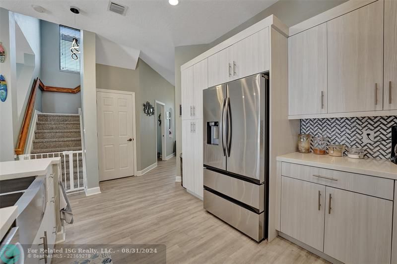 Entry with the garage access on the left and half bath on the right leading to the kitchen and living room.