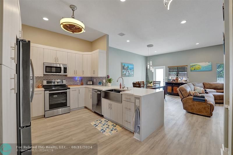 Entry with the garage access on the left and half bath on the right leading to the kitchen and living room.