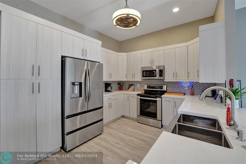 Entry with the garage access on the left and half bath on the right leading to the kitchen and living room.