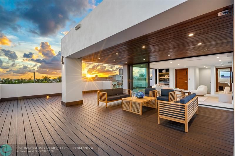 Outside sitting area on the third level with outdoor kitchen, jacuzzi, and firepit.