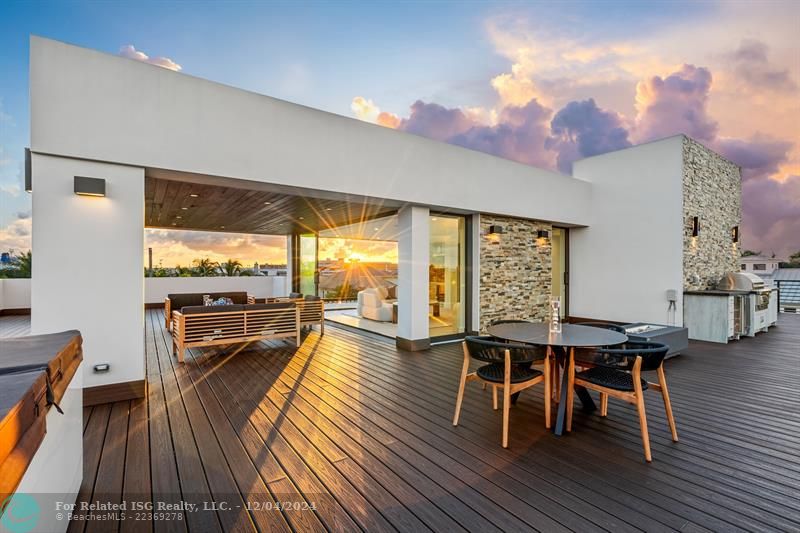 Outside sitting area on the third level with outdoor kitchen, jacuzzi, and firepit.