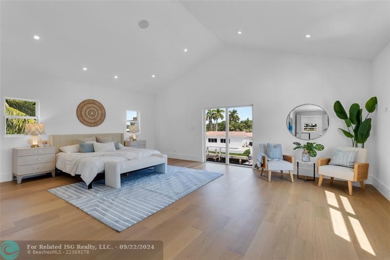 primary bedroom with sitting area and balcony with the canal views