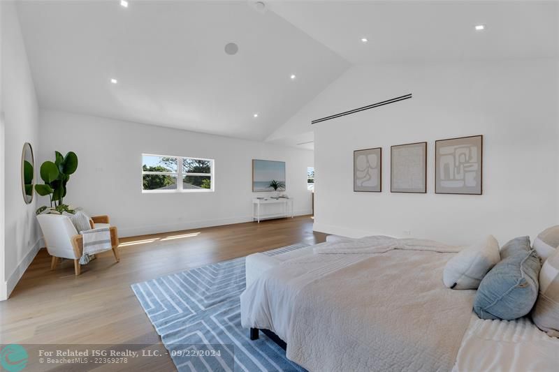 primary bedroom with sitting area and balcony with the canal views