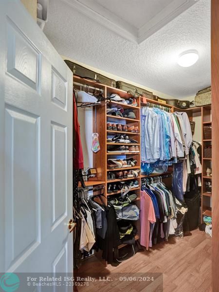 large walk-in closet with custom cabinetry/built-ins