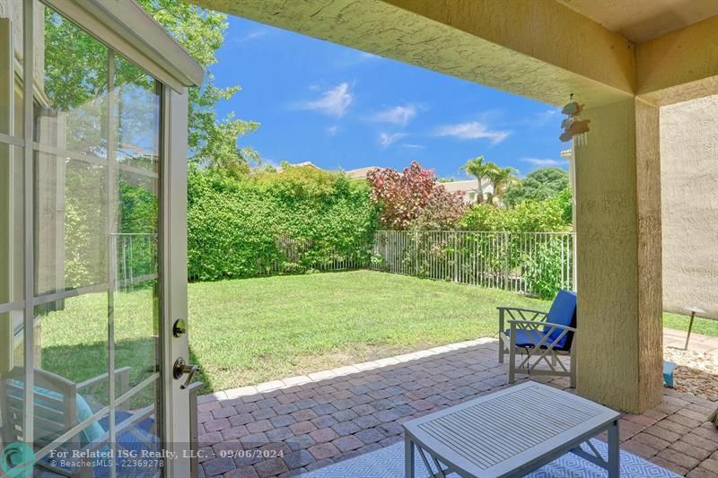 covered patio with extended patio pavers and large fully fenced in yard