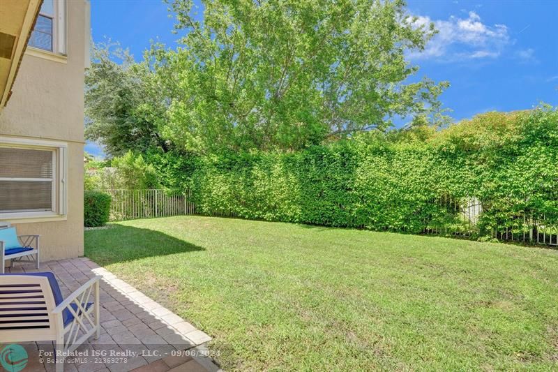 covered patio with extended patio pavers and large fully fenced in yard