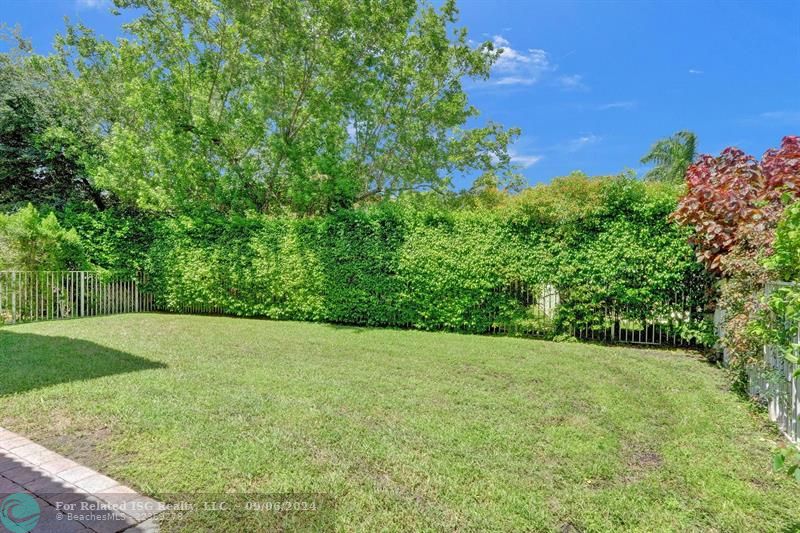 covered patio with extended patio pavers and large fully fenced in yard