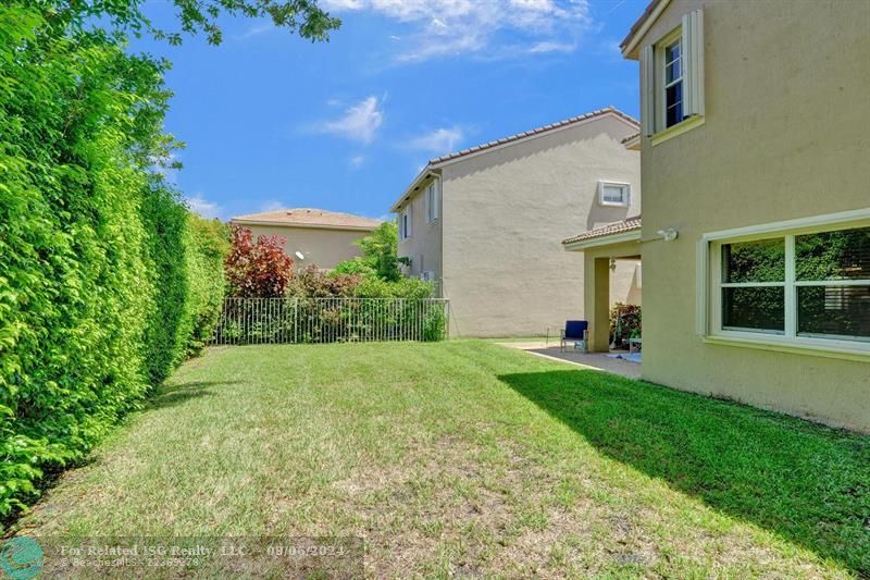 covered patio with extended patio pavers and large fully fenced in yard