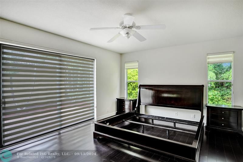 A large master bedroom featuring beautiful wood flooring.